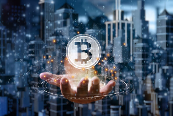 Outstretched hand with bitcoin symbol hovering above it.