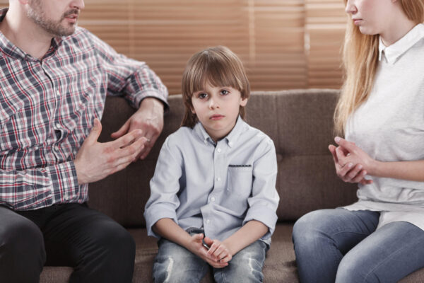 Close-up of sad child while parents arguing. Problem in the family