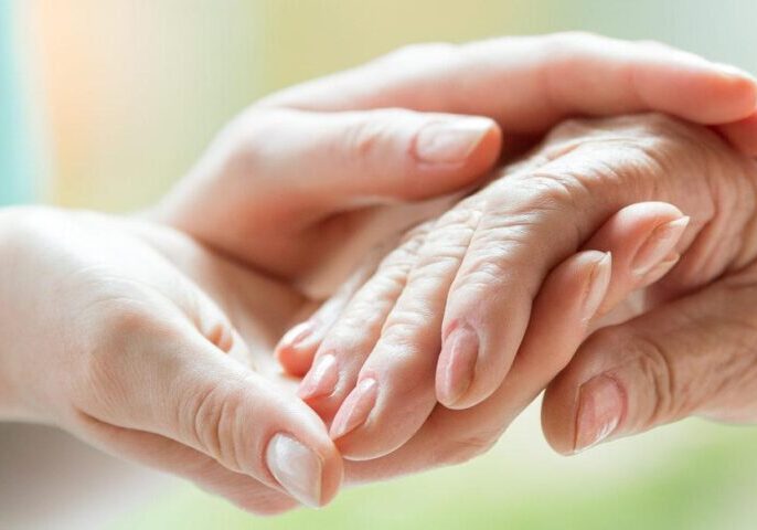 Compassionate individual holding the hand of an elderly person, symbolising support related to Court of Protection matters.