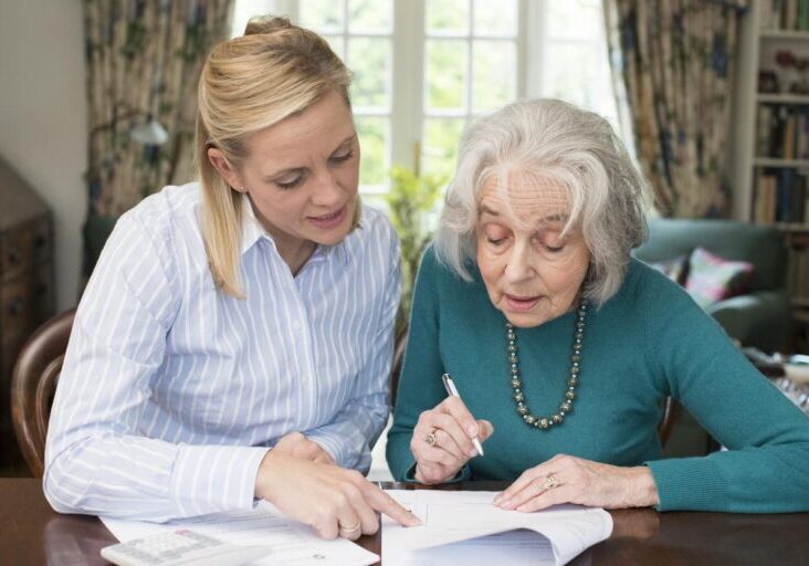 Elderly-woman-signing-a-document