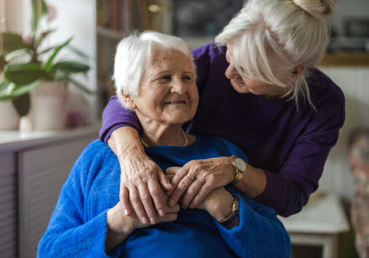 Middle-aged-daughter-giving-elderly-mother-a-hug