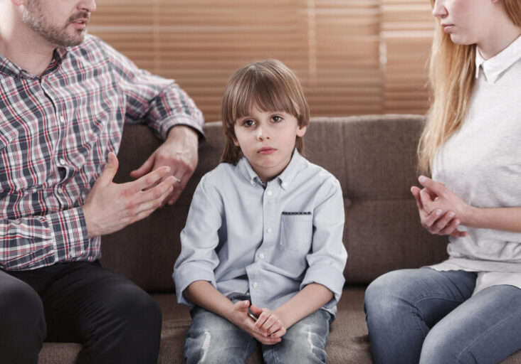 Close-up of sad child while parents arguing. Problem in the family