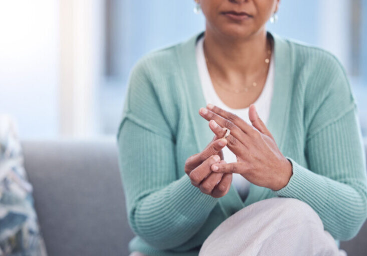 Doubt, stress and hands taking off ring for a divorce after marriage conflict, toxic relationship or cheating. Anxiety, mental health or sad senior woman removing her engagement ring after fighting Doubt, stress and hands taking off ring for a divorce after marriage conflict, toxic relationship or cheating. Anxiety, mental health or sad senior woman removing her engagement ring after fighting